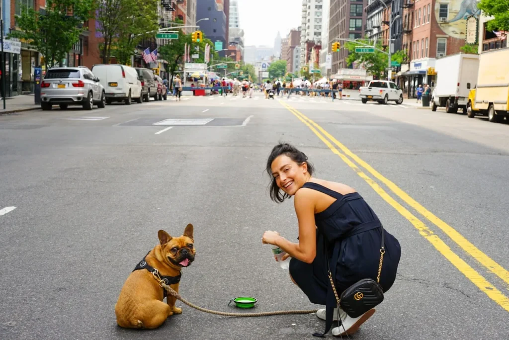 woman and dog squatting in middle of street