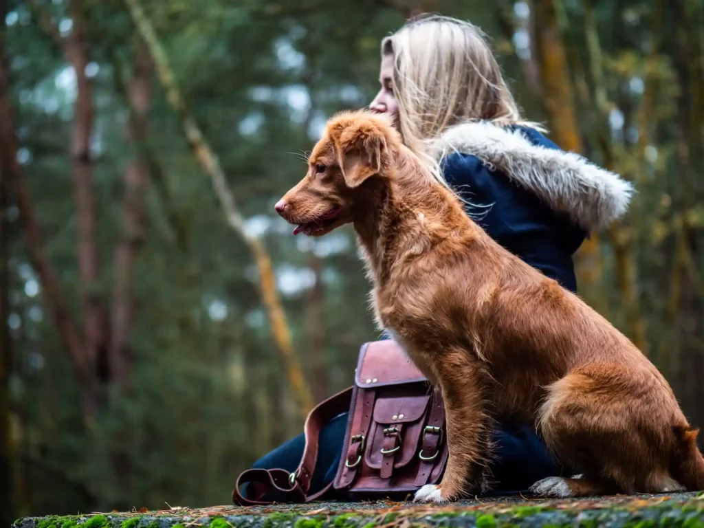 women and dog sitting besides each other